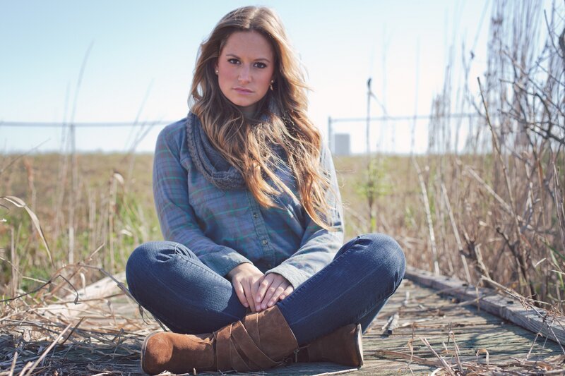 woman sitting on wooden path