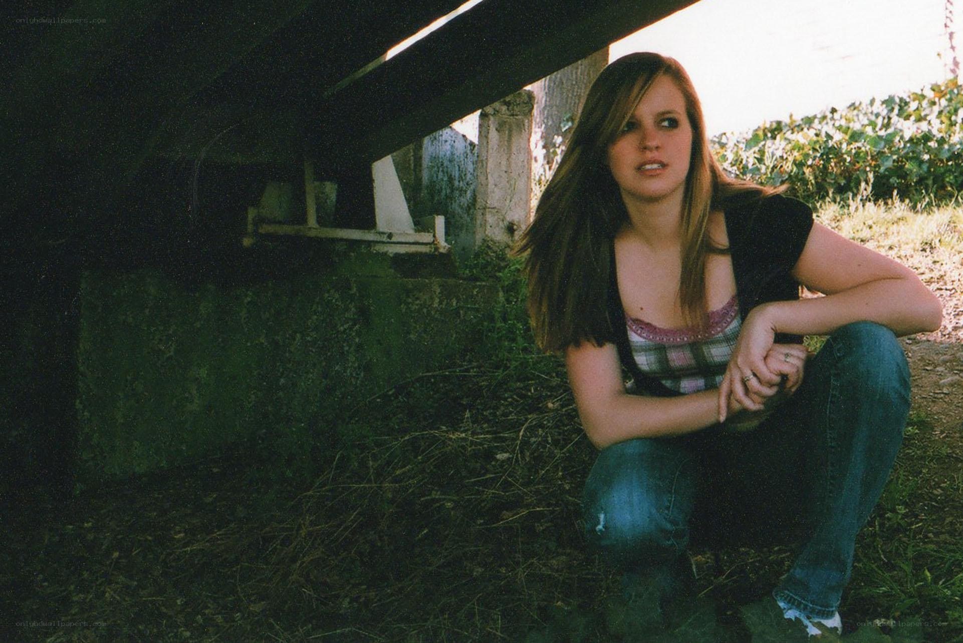 woman sitting under a bridge