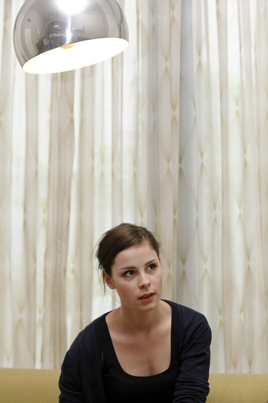 woman sitting under a lamp