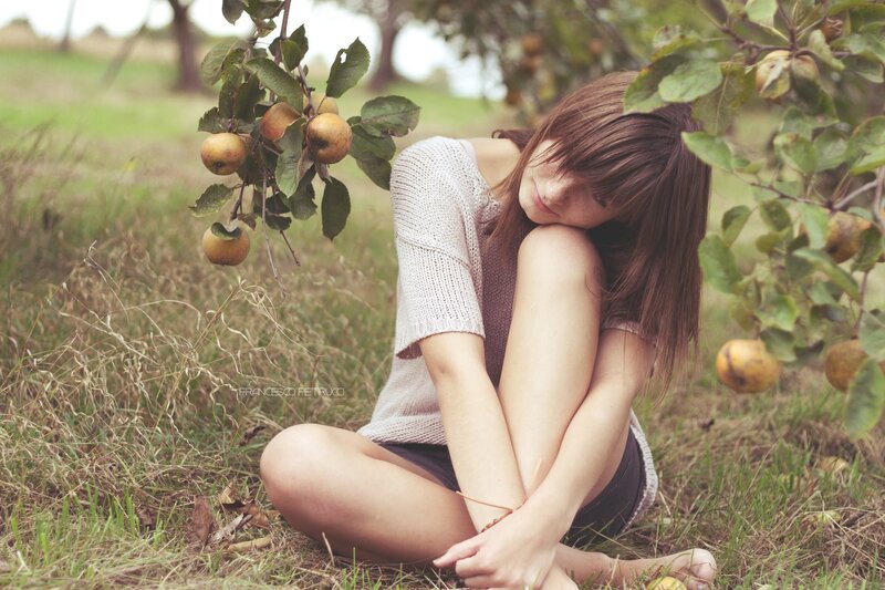 woman sitting under apple tree
