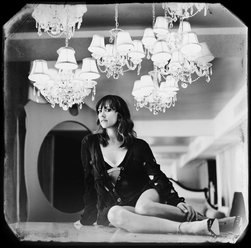woman sitting under chandeliers
