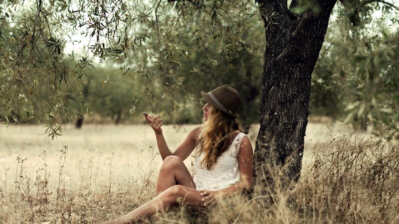 woman sitting under olive tree