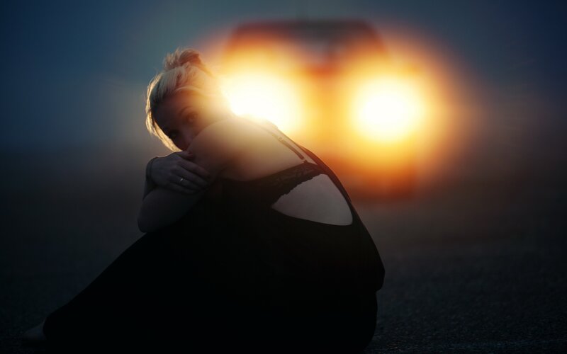 woman sitting with car lights