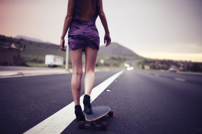woman skateboarding on road