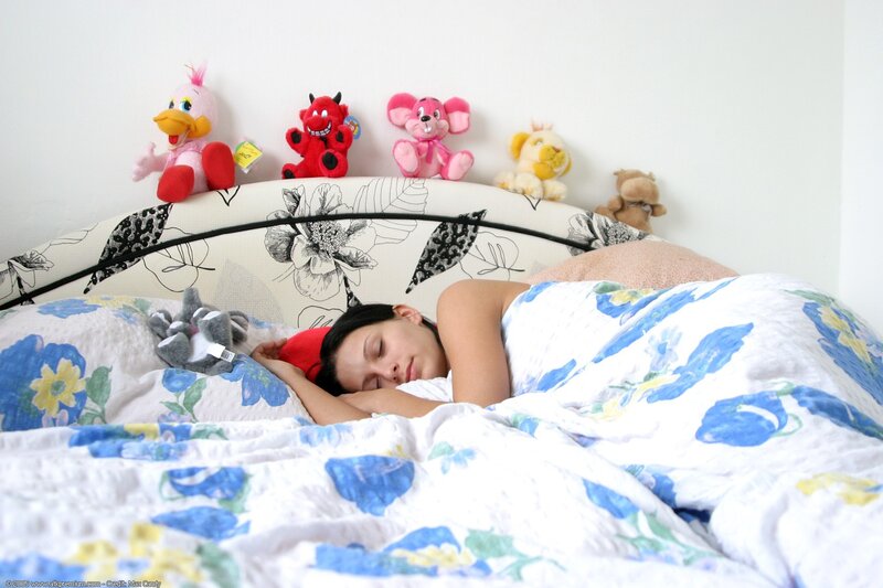 Woman sleeping in bed with toys