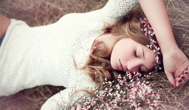 woman sleeping in hay with flowers