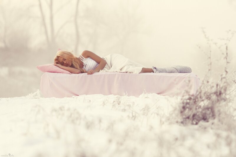 Woman sleeping on bed in snow