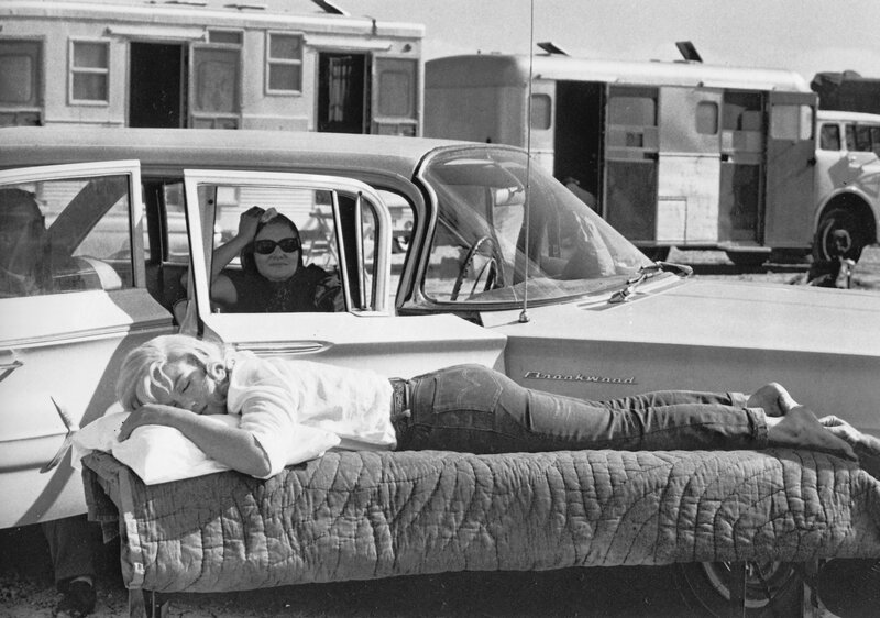 Woman sleeping on car trunk