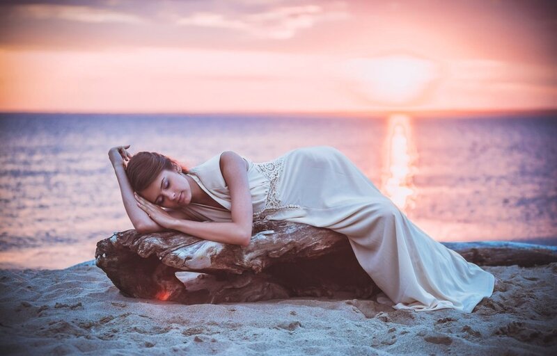 Woman Sleeping on Driftwood