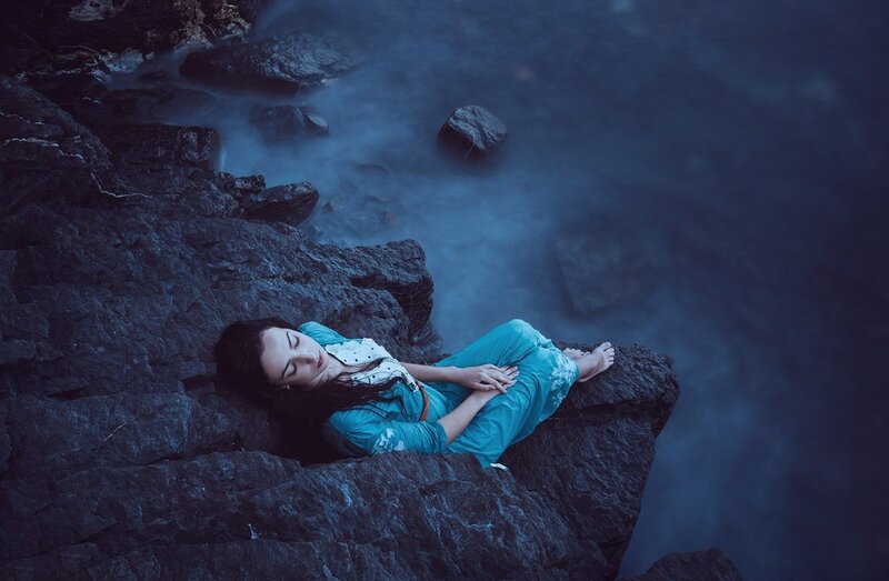 Woman Sleeping on Rocks — Blue