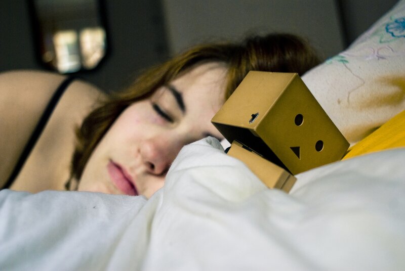 Woman sleeping with cardboard robot