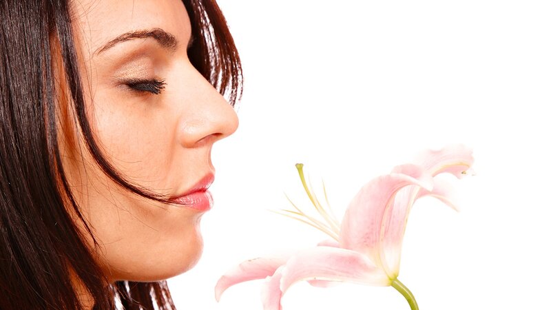 woman smelling a lily flower