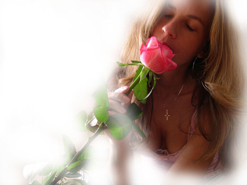 woman smelling a pink rose