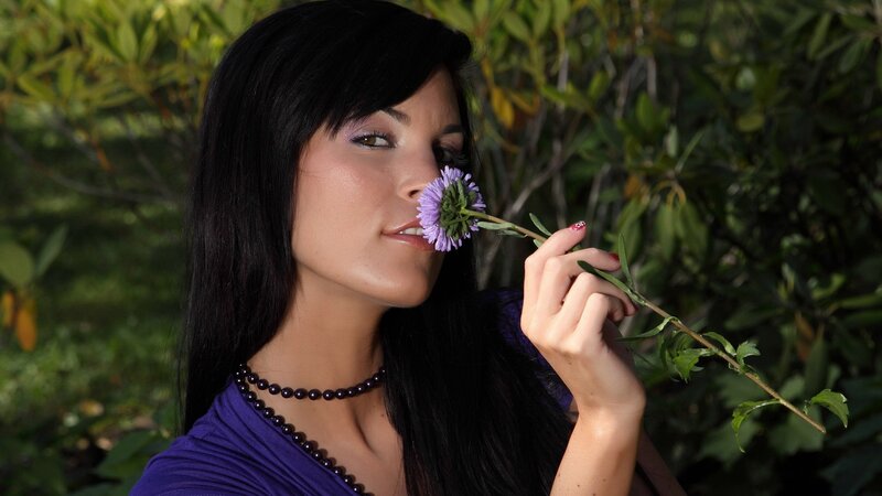 woman smelling a purple flower