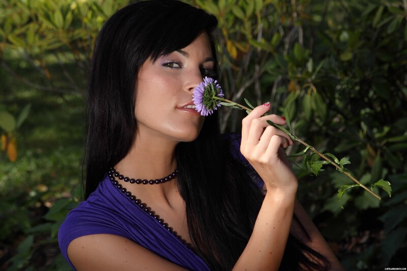 woman smelling a purple flower