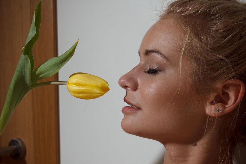 woman smelling a yellow tulip