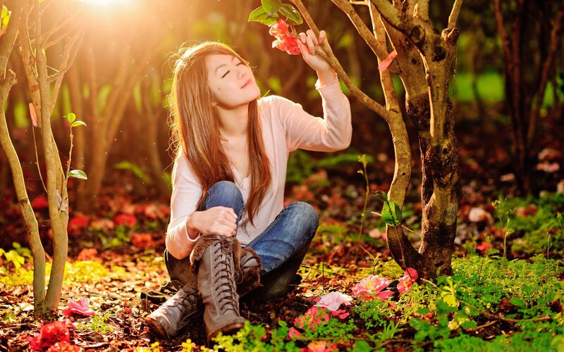 Woman smelling flowers in garden