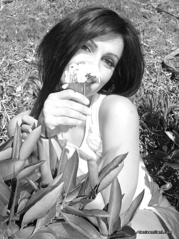 woman smelling flowers outdoors