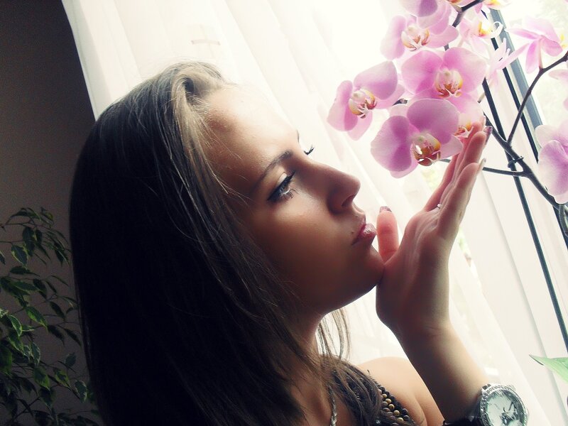 woman smelling orchid flower