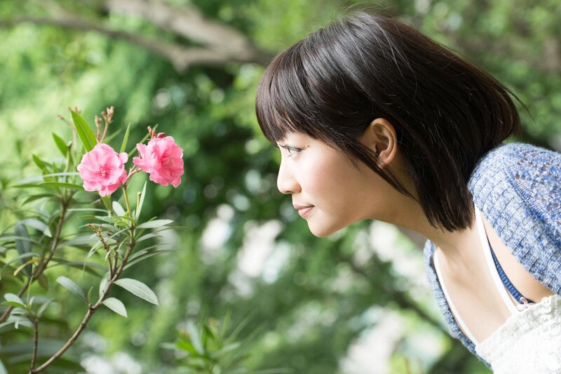 woman smelling pink flowers