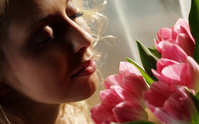 woman smelling pink tulips