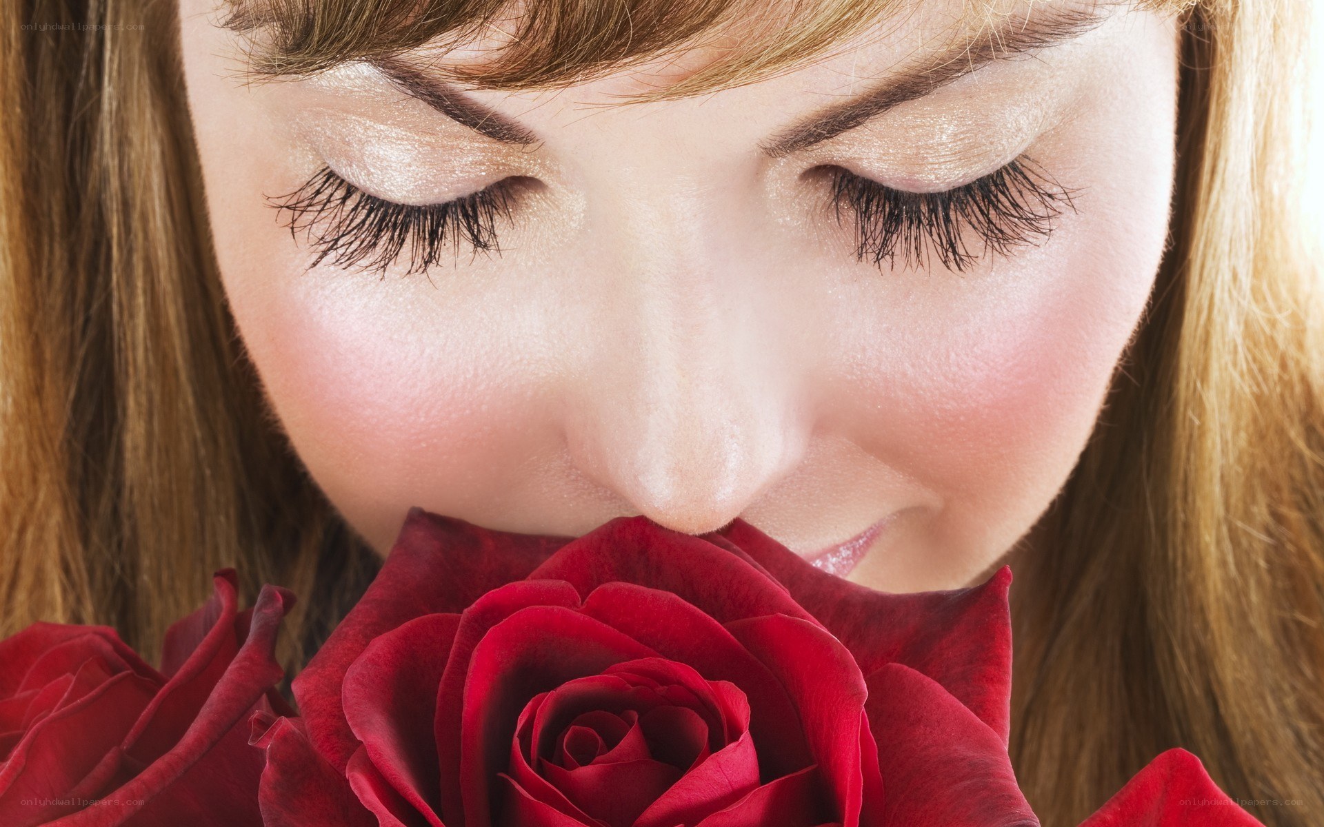 woman smelling red rose