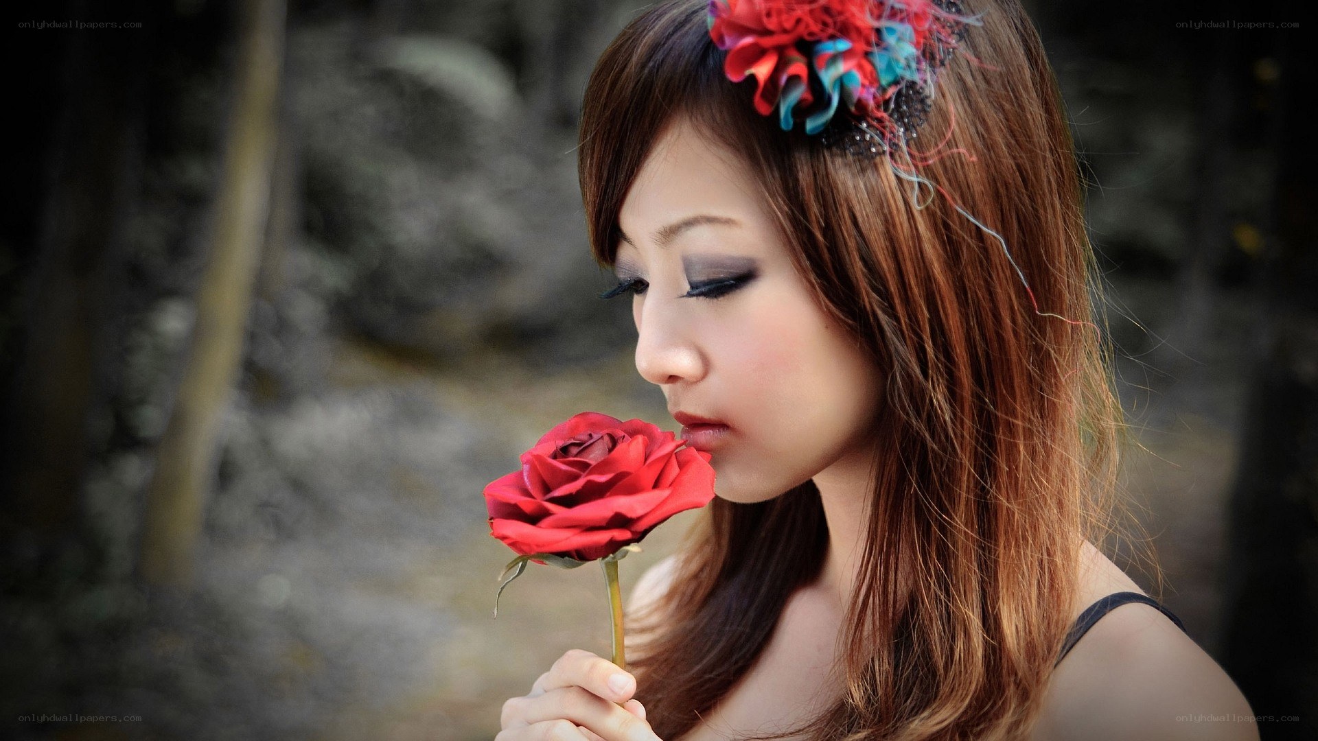 woman smelling red rose