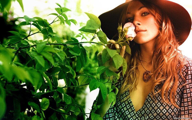 woman smelling rose in garden
