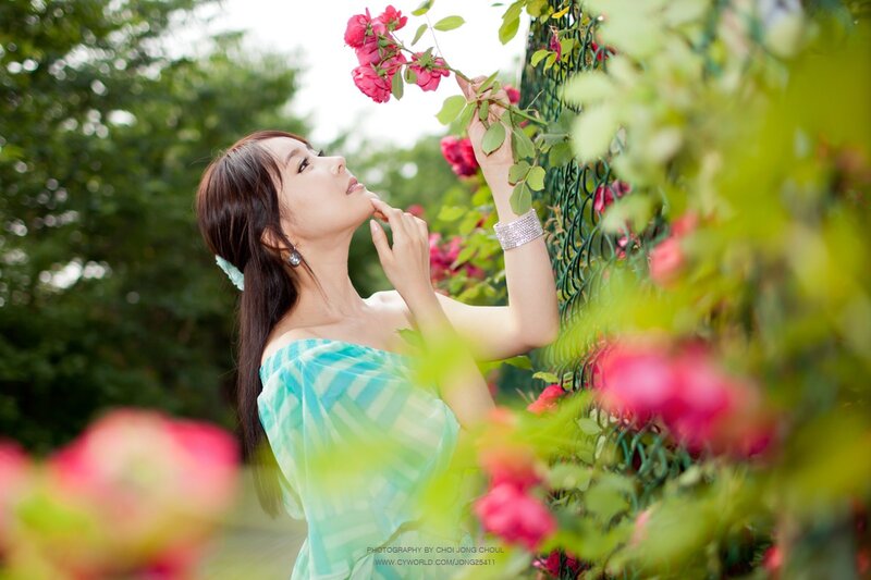 woman smelling roses in garden