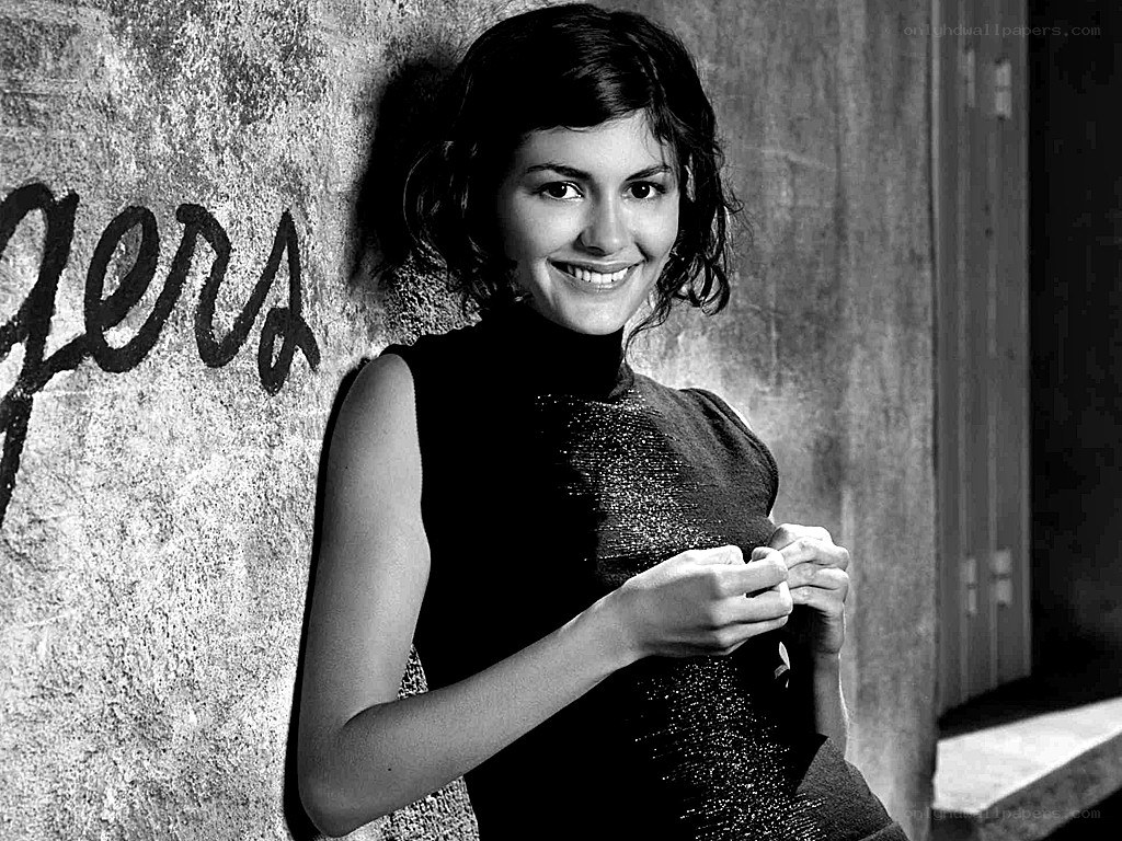 woman smiling against a wall
