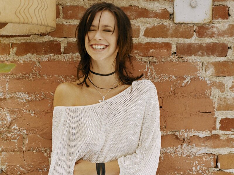 Woman smiling against brick wall