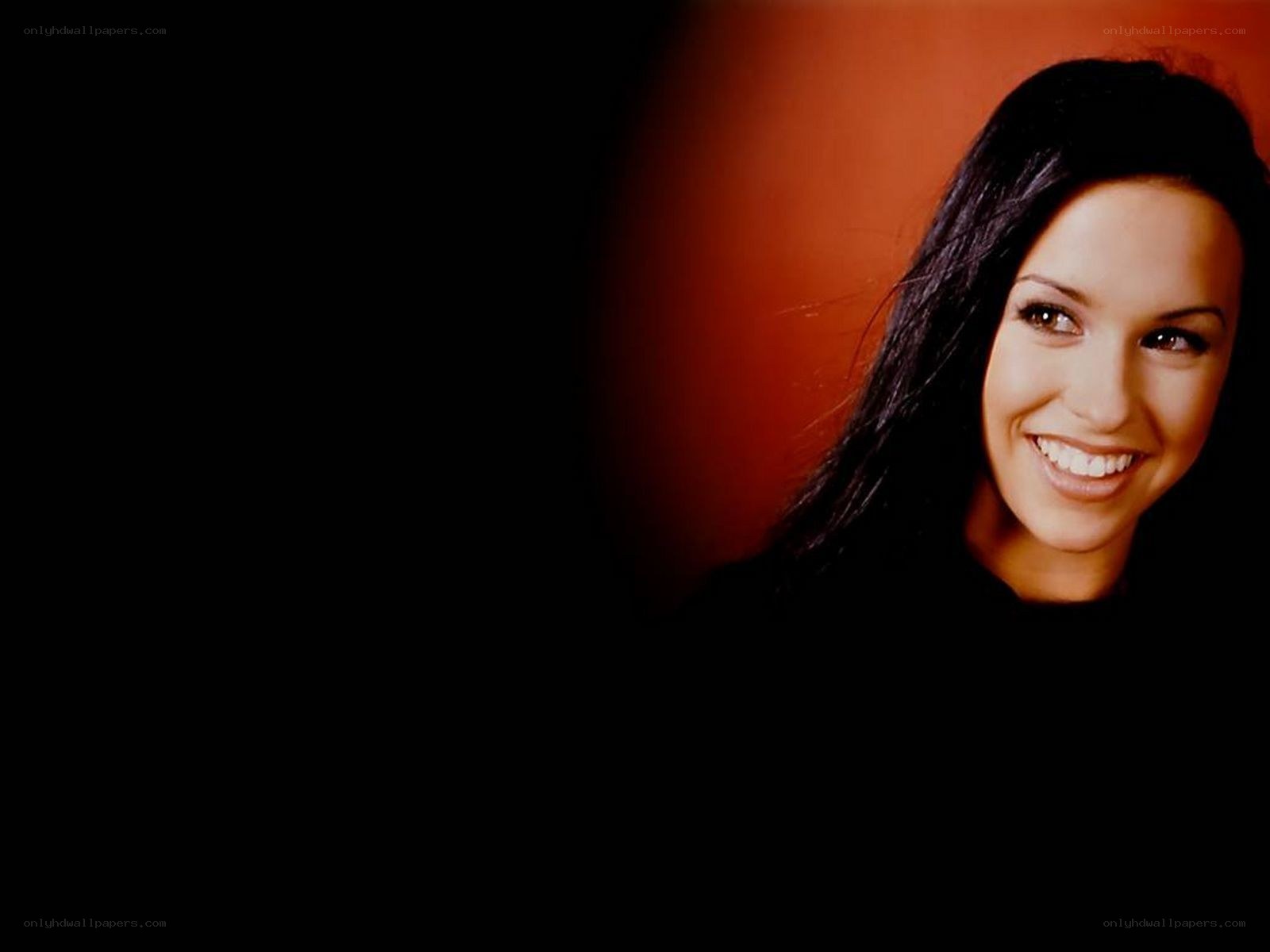 woman smiling against dark background