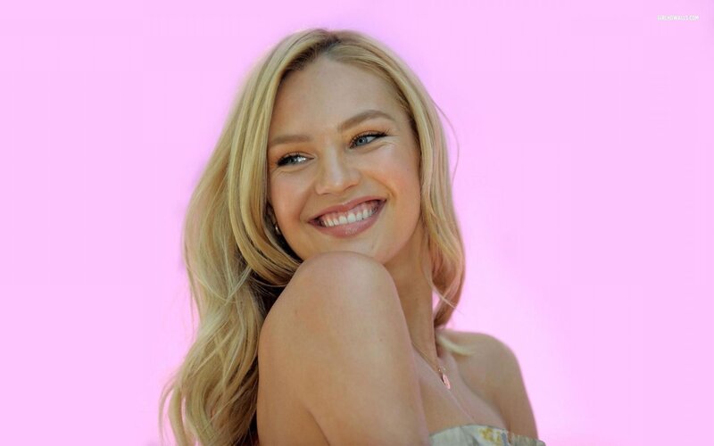 woman smiling against pink background
