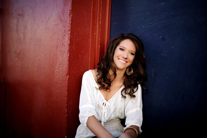 woman smiling against red and blue wall