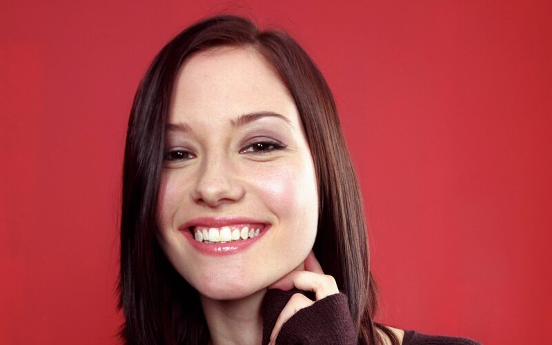 woman smiling against red background