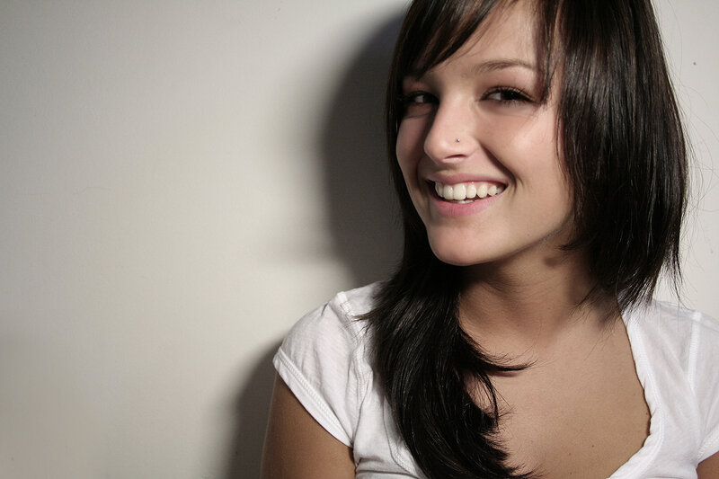 woman smiling against white wall