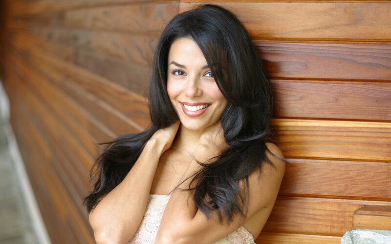 woman smiling against wood wall