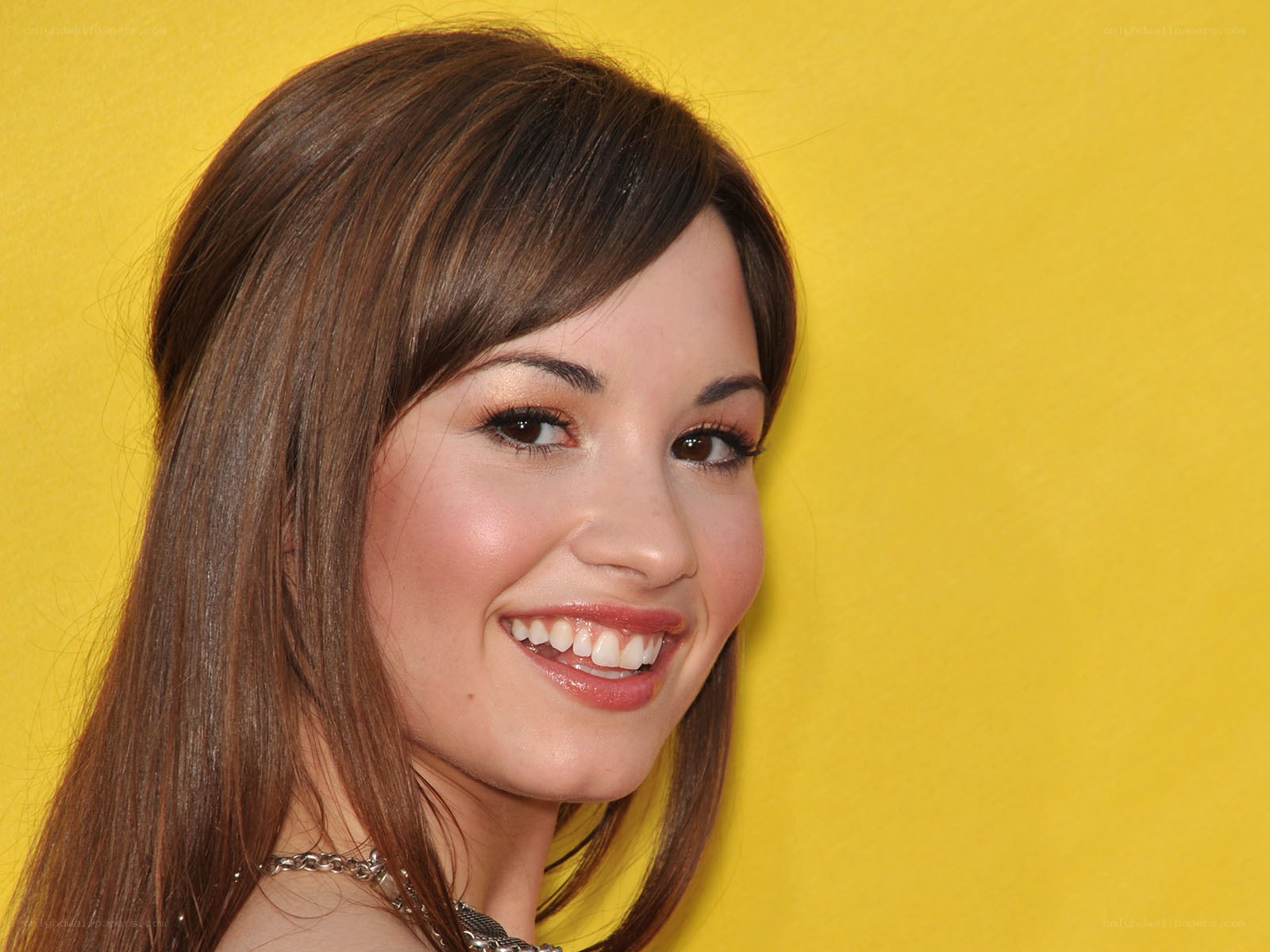 woman smiling against yellow background