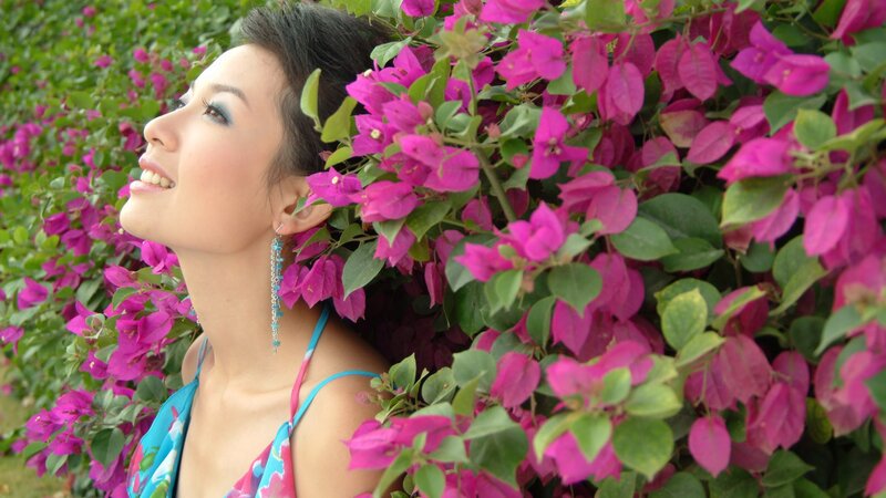 woman smiling among pink flowers