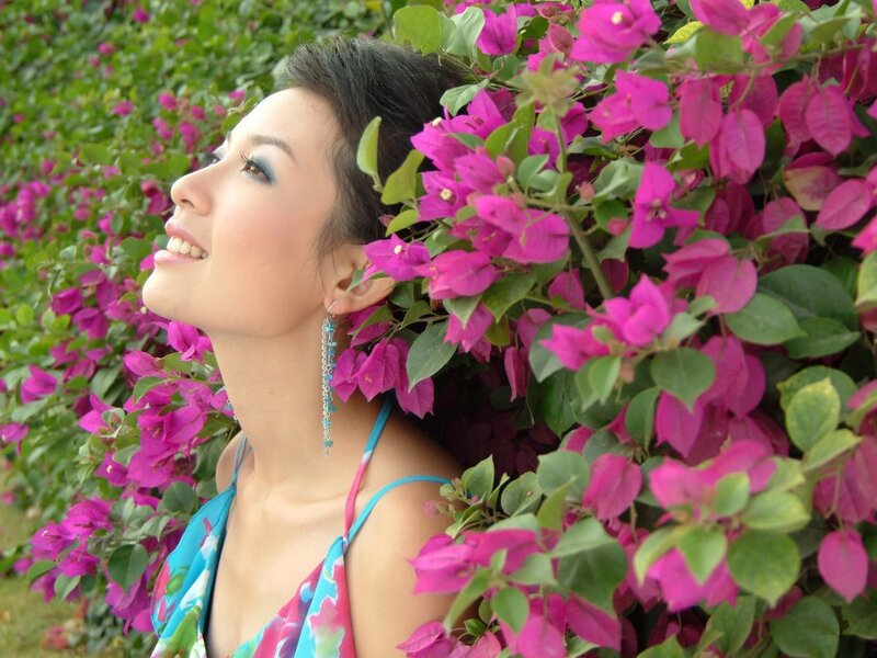 woman smiling among pink flowers