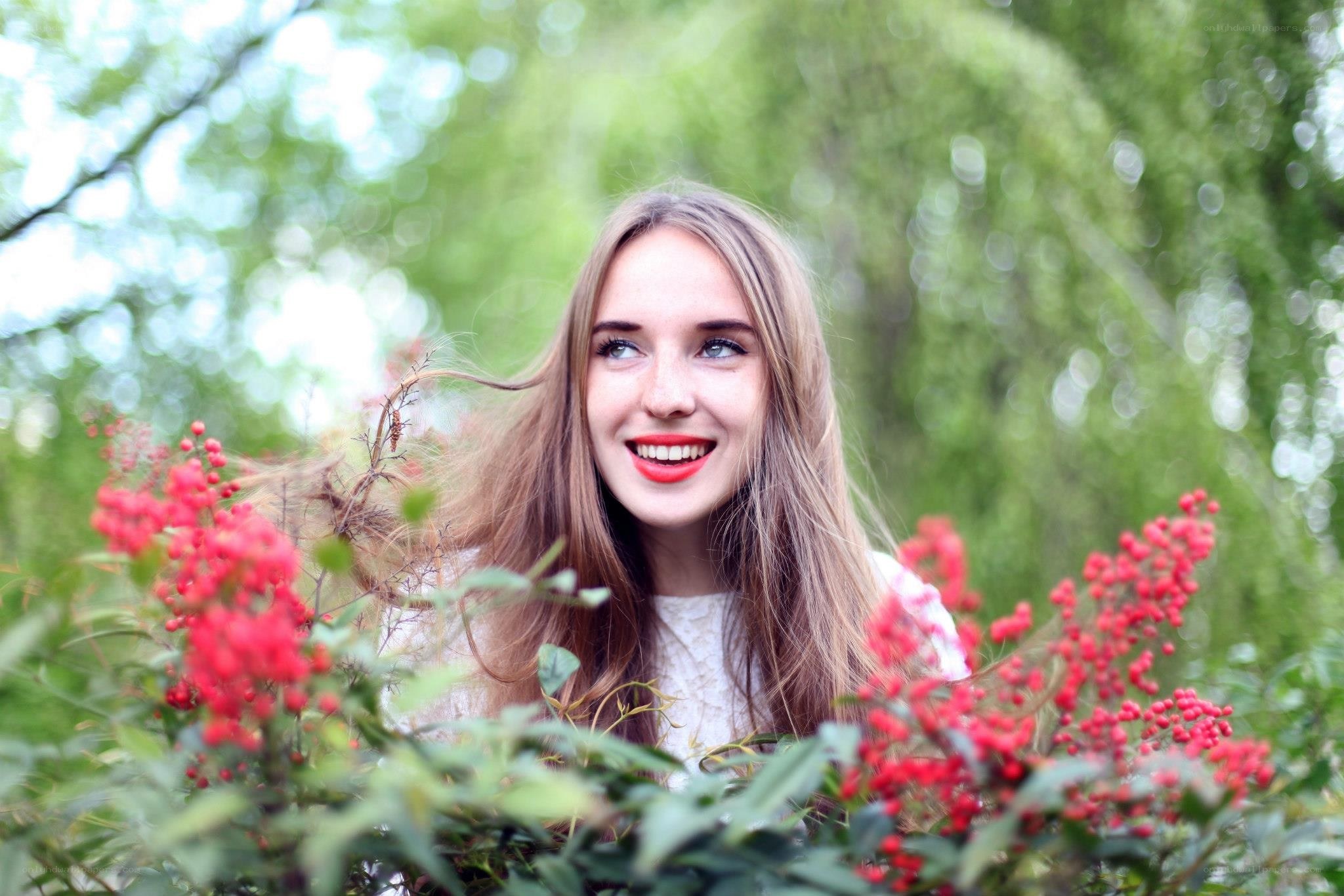 woman smiling among red berries