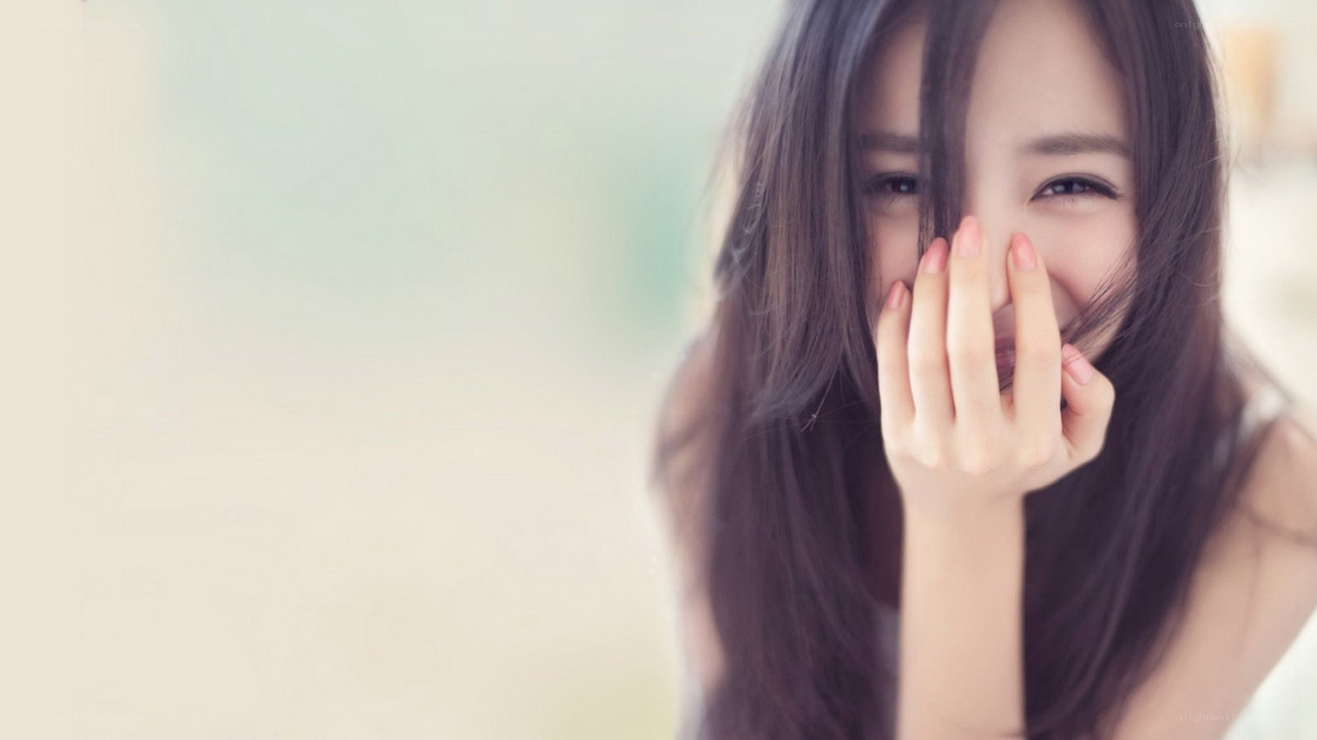 woman smiling behind hand