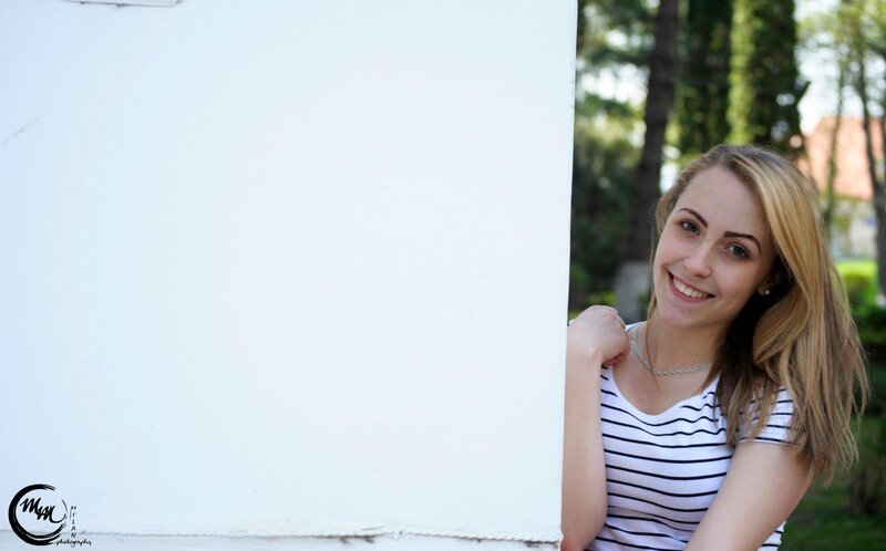 woman smiling behind wall