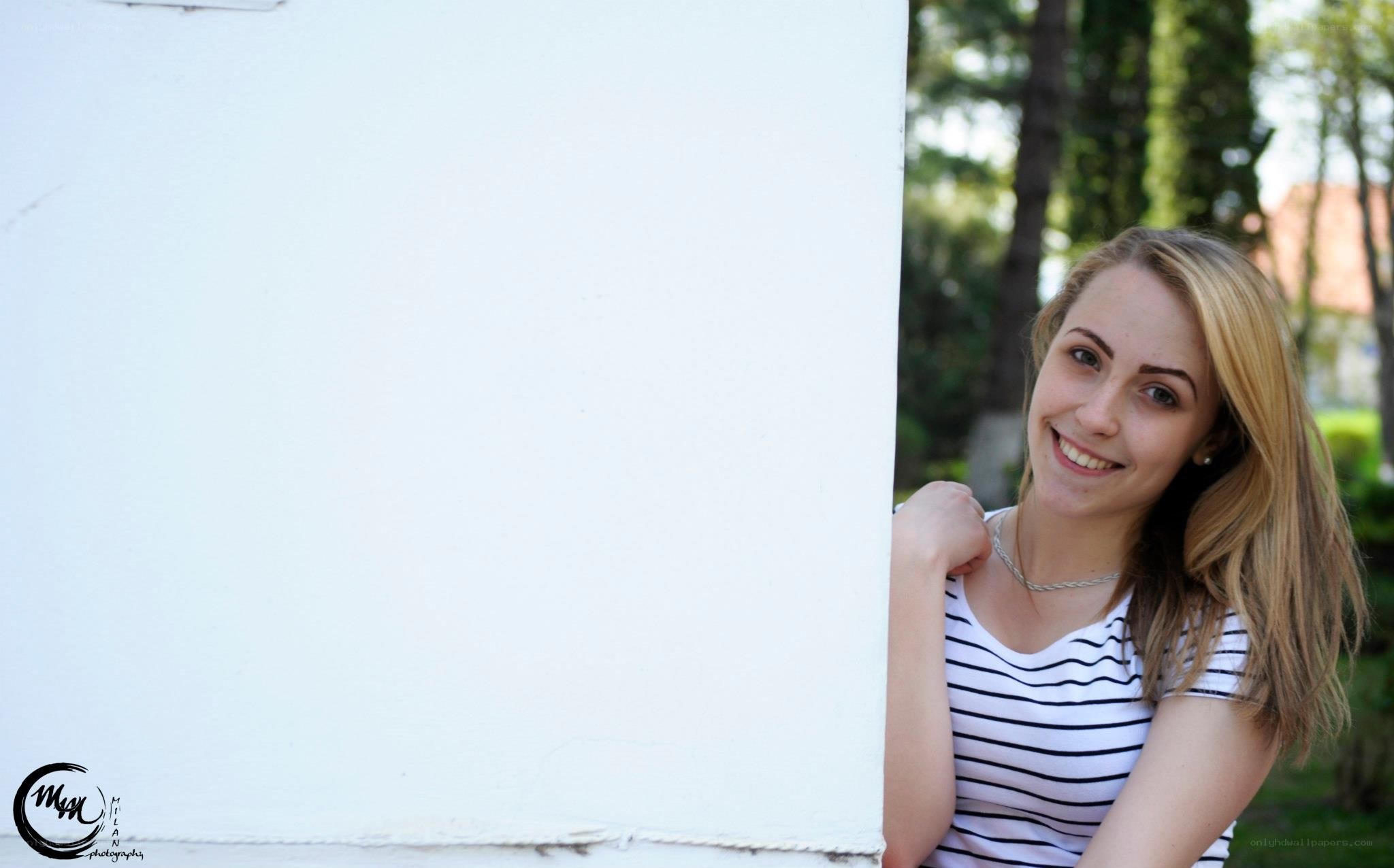 woman smiling behind wall