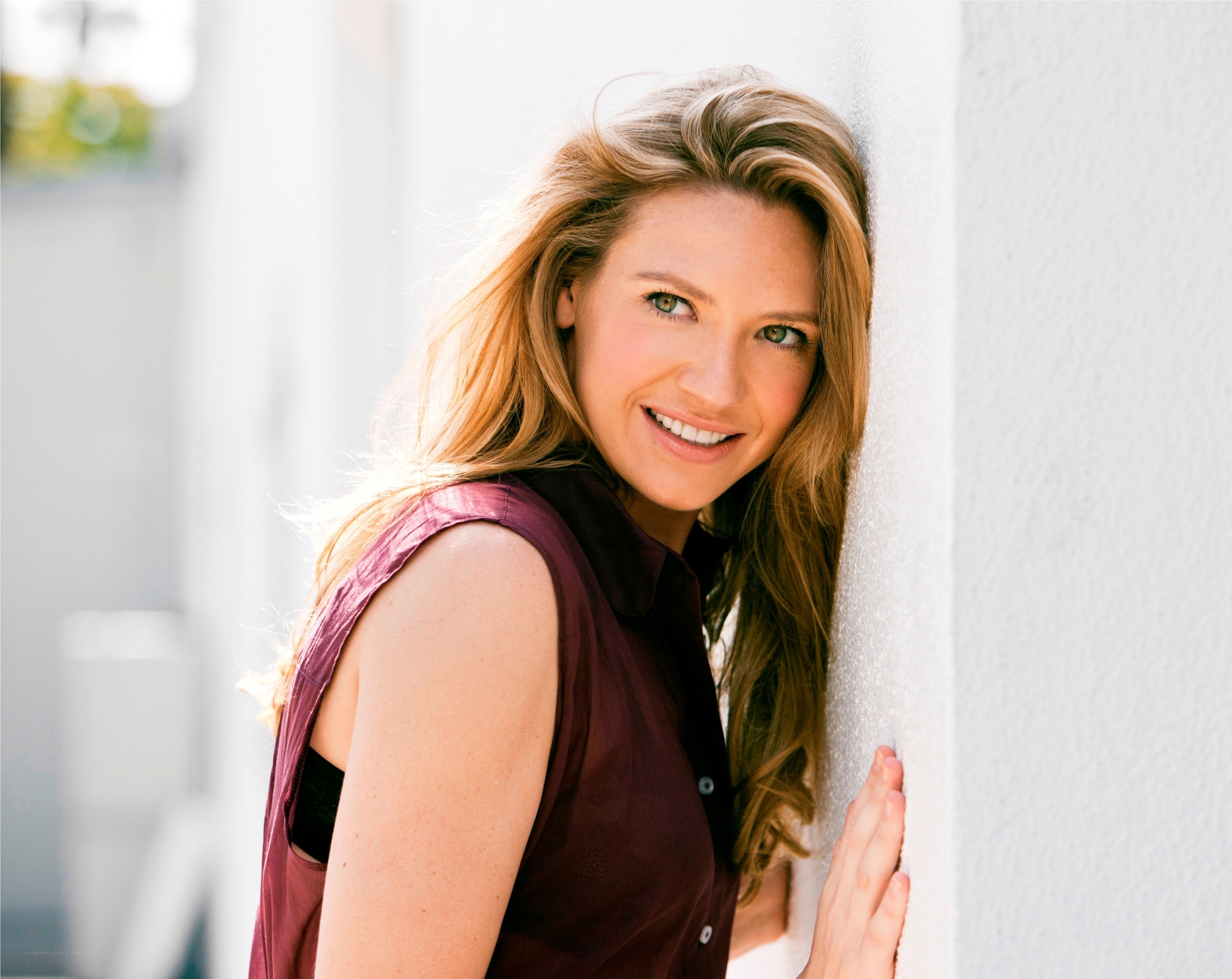 woman smiling by a wall