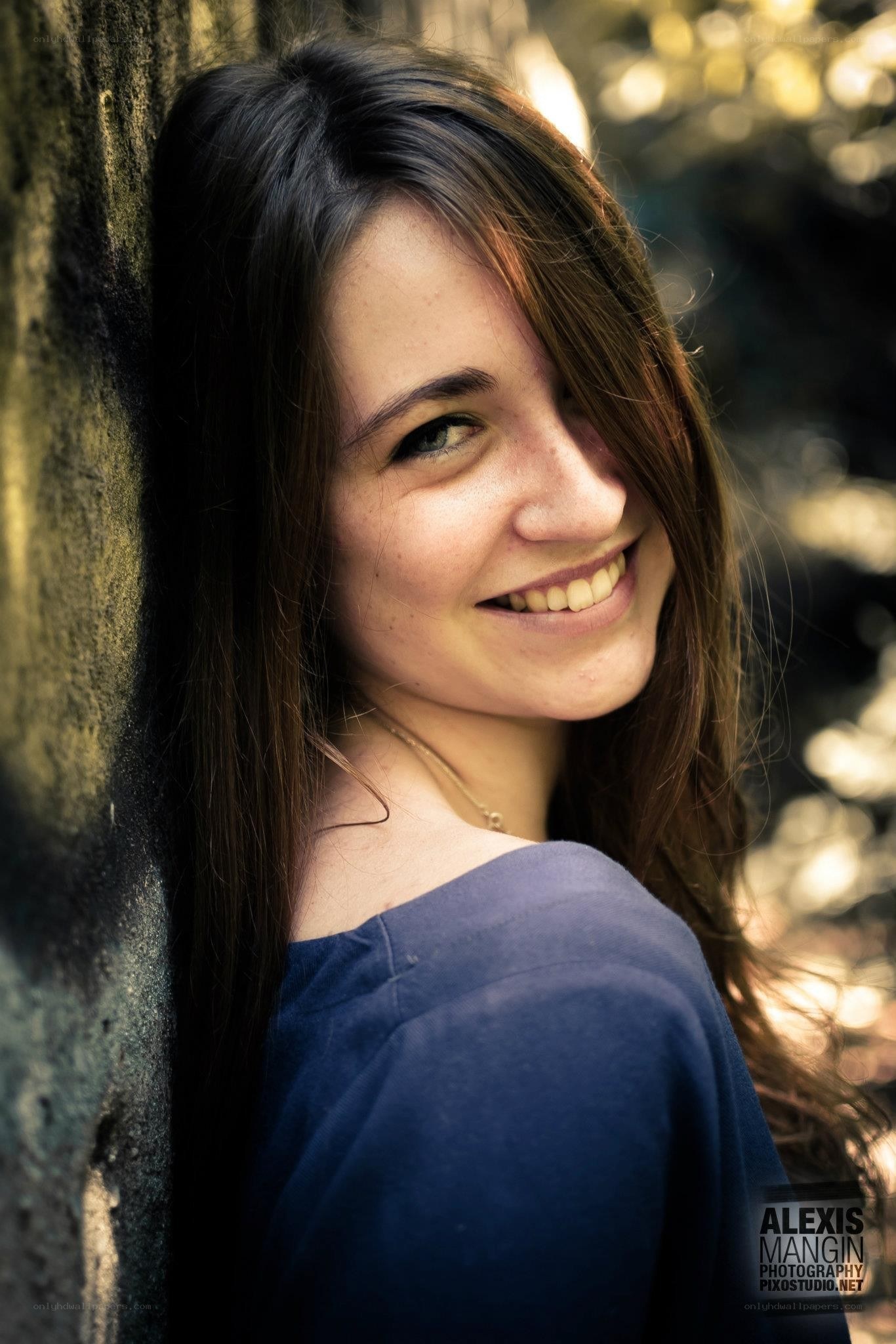 woman smiling by a wall