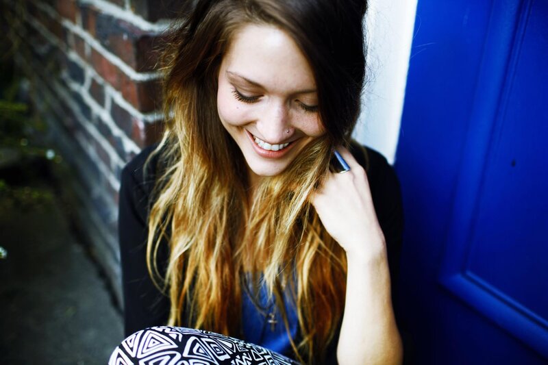 woman smiling by blue door