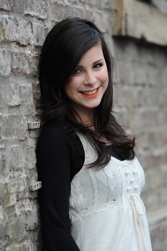 woman smiling by brick wall