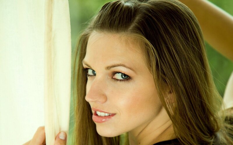 woman smiling by curtain