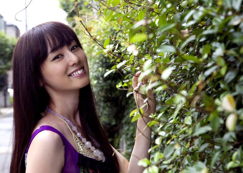 woman smiling by green bush